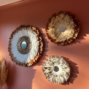 Trendy interior design, TRIO of jujuhats in natural terracotta, beige, white and gold feathers, raffia and gold brass mirrors
