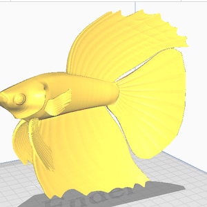 May include: A 3D printed model of a yellow betta fish with flowing fins. The fish is posed in a swimming position with its tail extended.