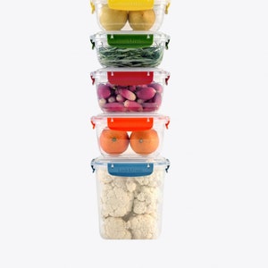 May include: A stack of five clear plastic containers with colourful lids. The containers are filled with various fruits and vegetables, including lemons, rosemary, radishes, oranges, and cauliflower. The lids have the text "Lock & Fresh" printed on them.