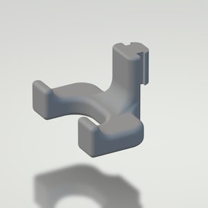 Peut inclure: Un support mural en plastique gris avec deux crochets. Les crochets sont incurvés et conçus pour tenir des objets comme un balai ou une serpillère.