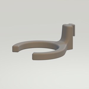 May include: A gray plastic wall mount holder with a circular opening for a bottle or other object. The holder has a small tab on the side for hanging.