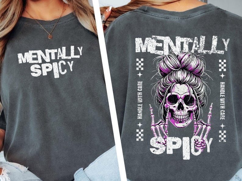 K&ouml;nnte beinhalten: Dunkelgraues T-Shirt mit den Worten "MENTALLY SPICY" in Wei&szlig;. Auf der R&uuml;ckseite befindet sich ein Totenkopf mit einem rosa Dutt und Skeletth&auml;nden, die eine Rock'n'Roll-Geste machen, mit dem Wort "SPICY" darunter.