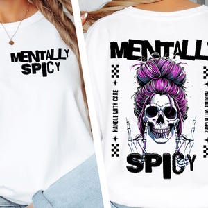 K&ouml;nnte beinhalten: Wei&szlig;es Langarmshirt mit dem Text "MENTALLY SPICY" auf der Vorderseite. Auf der R&uuml;ckseite befindet sich ein Totenkopf mit lila Haaren und den Worten "MENTALLY SPICY" und "HANDLE WITH CARE".