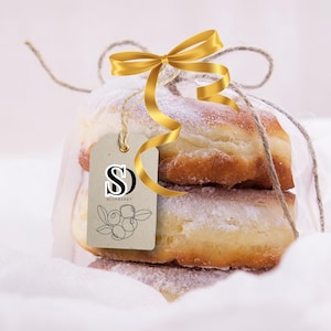 May include: Two powdered donuts tied with a gold ribbon and a brown tag that says "SD Blueberry".