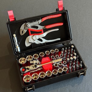 May include: Black tool case with red accents, open to reveal various tools. Includes pliers, sockets, and bits. The text "BLEMISH ITEM - PLEASE READ DESCRIPTION CAREFULLY" and "TOOLS NOT INCLUDED" are visible.