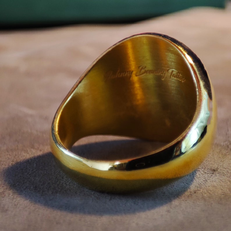 This high-resolution product image features an engraved initial signet ring with a custom monogram design. The ring’s top surface showcases detailed initials, while the band remains polished and minimal. Offered in Gold Plated, 14k Gold, and Silver versions, the piece matches various styles. The lighting highlights the reflective finish and fine engraving, reinforcing the ring’s appeal as a personalized holiday or Christmas gift for someone important.