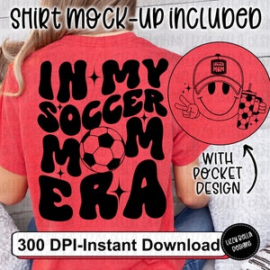 May include: Red t-shirt with black text that reads "In My Soccer Mom Era" with a soccer ball graphic. A separate image shows a smiling face with a baseball cap that says "Soccer Mom" and a cup with a soccer ball graphic.
