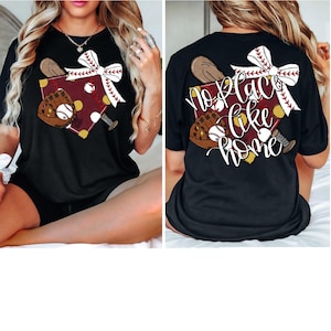 May include: Black t-shirt with a baseball-themed design on the front and the text "No place like home" on the back. The design includes a baseball bat, a baseball glove, and a baseball.