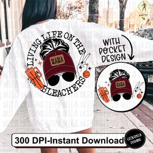 May include: A white sweatshirt with a graphic design of a woman wearing a baseball cap with the word "Mama" on it. The graphic also includes a basketball, a drink, and the text "Living Life on the Bleachers".