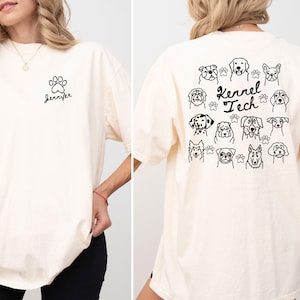 May include: Ivory-colored t-shirt with a black paw print and the name "Jennifer" on the front. The back of the shirt features various dog illustrations and the text "Kennel Tech".