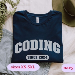May include: Navy blue t-shirt with the text "CODING SINCE 2024" in white. The shirt is available in sizes XS-5XL.