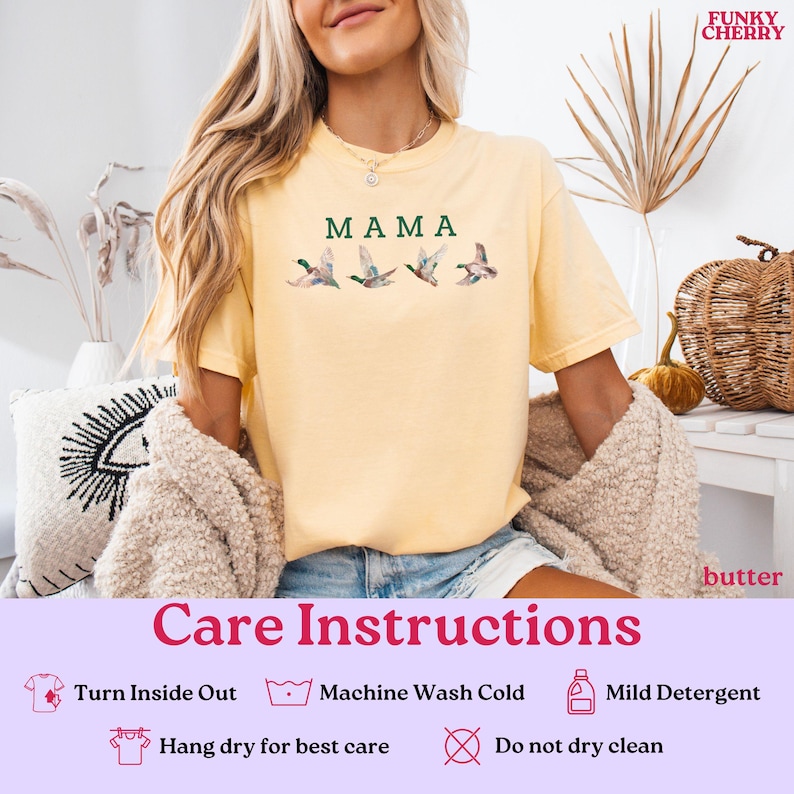 Peut inclure: T-shirt jaune beurre avec le mot "MAMA" en vert et une illustration &agrave; l'aquarelle de quatre canards en vol. Le t-shirt a des manches courtes et un col rond. Le logo Funky Cherry est dans le coin sup&eacute;rieur droit.