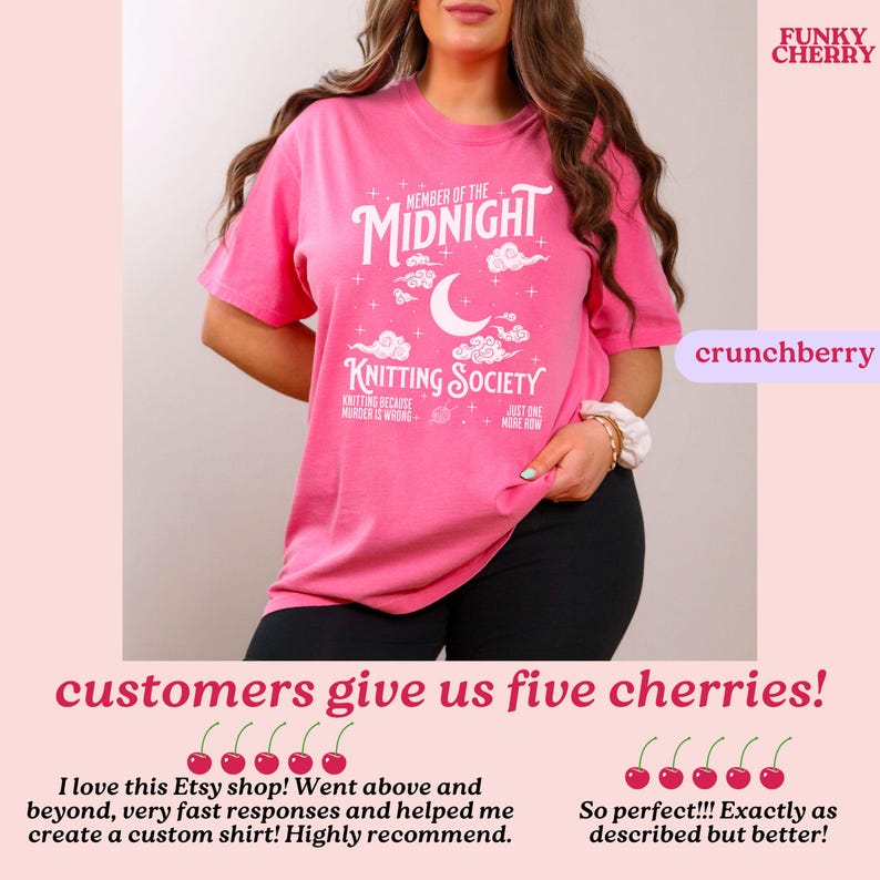 May include: A pink t-shirt with the text "MEMBER OF THE MIDNIGHT KNITTING SOCIETY" in white. The design includes a crescent moon and clouds. The shirt also has the text "KNITTING BECAUSE MURDER IS WRONG" and "JUST ONE MORE ROW".