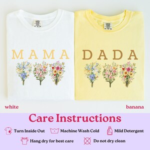 May include: Two t-shirts, one white and one banana yellow, are displayed. The white shirt has the word "MAMA" printed on it, and the yellow shirt has "DADA." Both shirts feature floral bouquet designs. The care instructions are also visible.