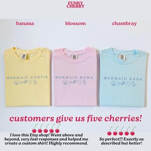 Puede incluir: Tres camisetas en amarillo, rosa y azul claro, cada una con un t&iacute;tulo "Mermaid" diferente y gr&aacute;ficos con tem&aacute;tica marina. El texto "Funky Cherry" est&aacute; en la parte superior. Las camisetas est&aacute;n etiquetadas como "banana", "blossom" y "chambray".