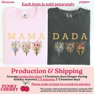 May include: Two t-shirts, one light pink and one dark gray, each with a floral bouquet design. The light pink shirt says "MAMA" in gold letters, and the dark gray shirt says "DADA".