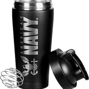 May include: Black shaker bottle with a silver lid and a silver inscription that reads "America's Navy" with a stylized eagle and anchor graphic. The bottle has a black mixing ball and a black lid with a flip top.
