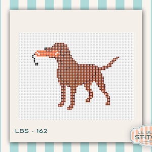 Puede incluir: Patr&oacute;n de punto de cruz de un perro marr&oacute;n sosteniendo un juguete naranja en la boca. El perro est&aacute; sobre un fondo blanco con el texto "LBS - 162". El logotipo de Le Beau Stitch est&aacute; en la esquina inferior derecha.