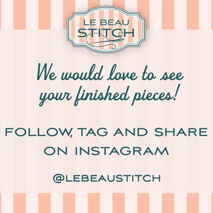 May include: A pink and white striped background with a white rectangle in the center. The rectangle contains the text "LE BEAU STITCH" in a teal blue font. Below the text is a smaller teal blue font that says "We would love to see your finished pieces!" Below that is the text "FOLLOW, TAG AND SHARE ON INSTAGRAM" in teal blue font. Below that is the text "@LEBEAUSTITCH" in teal blue font.