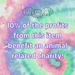 May include: A colorful tie-dye background with three dog head outlines at the top. Text in purple reads "10% of the profits from this item benefit an animal related charity!"