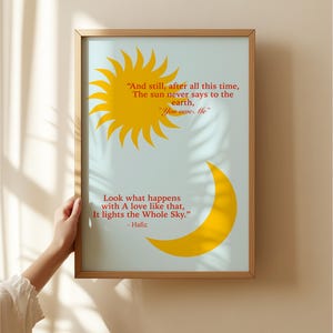 以下が含まれることがあります： 青い背景と黄色の太陽と月のイラストが描かれた額装されたプリント。プリントには、ハフィズの言葉が書かれています。「それでも、この長い年月を経て、太陽は地球にこう言ったことはありません。「あなたは私に借りがあります」そんな愛がもたらすものを見てください。それは、空全体を照らします。」