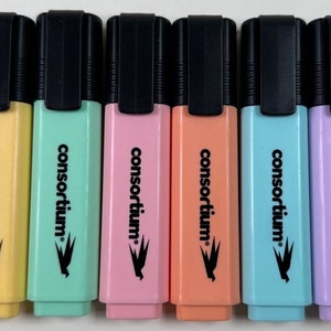 Puede incluir: Seis rotuladores fluorescentes de diferentes colores pastel: amarillo, verde, rosa, naranja, azul y morado. Cada rotulador tiene una tapa negra y la palabra "consortium" impresa en el lateral.