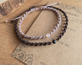 May include: Two macrame bracelets, one light brown and one dark brown, each with a central bead. The bracelets are on a brown card with text and leaf illustrations. The card reads "HE & HE" and "ONLY FOR ME".
