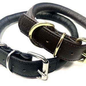 Peut inclure: Deux colliers pour chien en cuir. L'un est noir avec une boucle et un anneau en D argentés. L'autre est marron avec une boucle et un anneau en D dorés. Les deux colliers sont roulés et rembourrés.