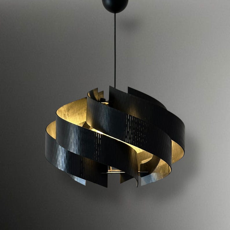 May include: A modern black pendant light fixture with a spiral design. The interior of the fixture has a gold finish, creating a warm glow. The light hangs from a black cord and ceiling mount.