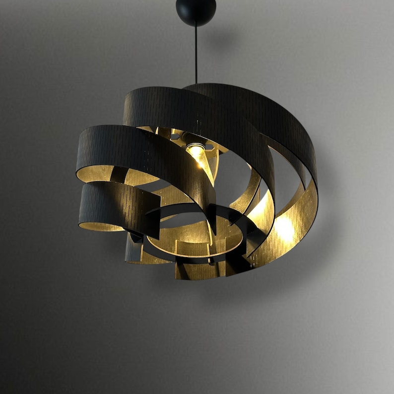 May include: A modern, black spiral pendant light fixture. The light has a series of curved, dark wooden bands that create a layered, open design. The interior of the bands has a warm, golden hue, and the light hangs from a black ceiling mount.