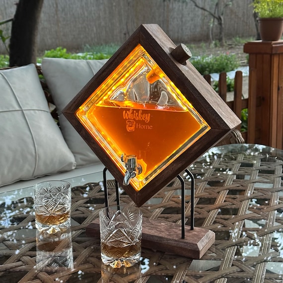A wall-mounted whiskey dispenser with a personalized engraved decanter and glasses — 504 favorites say couples and entertainers are genuinely excited by this conversation-starter bar piece.