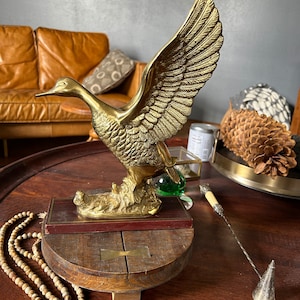 Duck in flight, brass sculpture