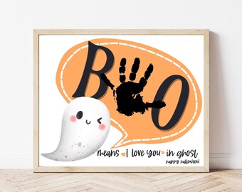 Puede incluir: Un estampado enmarcado con temática de Halloween con un fantasma blanco y una burbuja de diálogo que dice "BOO" con una huella de mano. El texto de abajo dice "means I love you in ghost" y "happy halloween!"