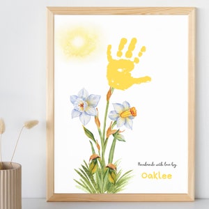 May include: A yellow handprint art print with a watercolor daffodil design. The print includes the text "Handmade with love by Oaklee".