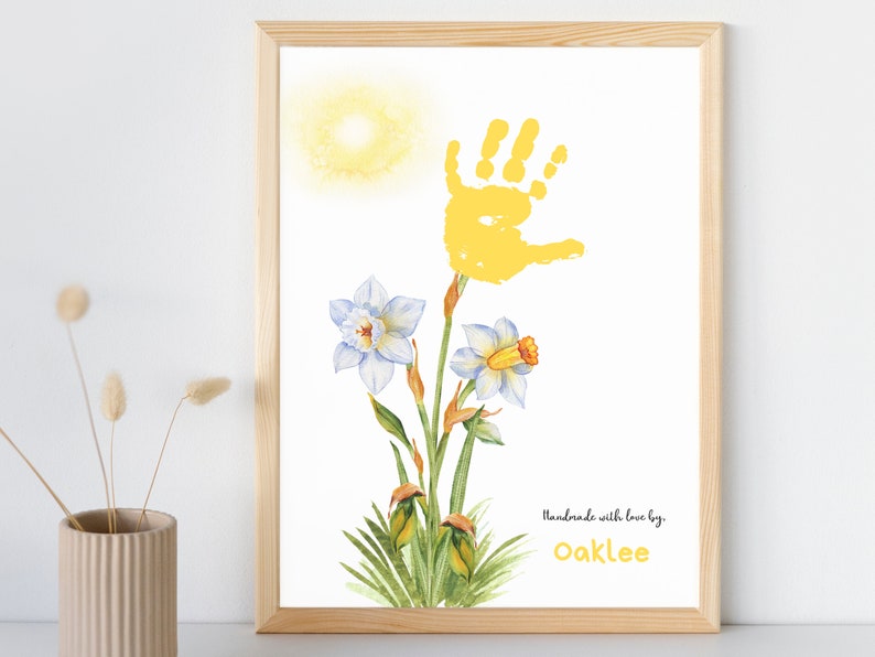 May include: A yellow handprint art print with a watercolor daffodil design. The print includes the text "Handmade with love by Oaklee".