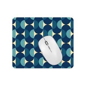 May include: A blue and cream geometric patterned mouse mat with a white wireless computer mouse on top.