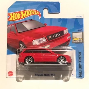 Puede incluir: Coche de fundición a presión rojo Audi Avant RS2 1994 Hot Wheels en un paquete de cartón azul y blanco. El coche es un modelo Factory Fresh, número 133/250, y forma parte de la serie 9/10. El paquete tiene el logotipo de Hot Wheels y las palabras "Factory Fresh" impresas en él.