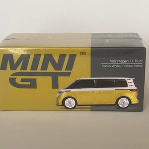 Puede incluir: Un modelo de coche Volkswagen ID. Buzz amarillo y blanco, expuesto en su caja original. La caja es amarilla y gris con el texto "MINI GT" y "Volkswagen ID. Buzz Candy White / Pomelo Yellow".