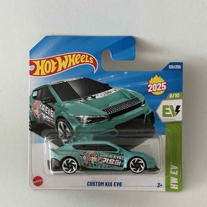 May include: A teal Hot Wheels die-cast toy car labelled "CUSTOM KIA EV6" with anime-style graphics. The packaging includes the Hot Wheels logo, the year 2025, and the number 120/250. The car is part of the HW EV series.