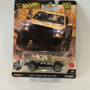 Può includere: Un'auto giocattolo Hot Wheels, modello pressofuso di una Ford F-150 Raptor del 2017, con livrea mimetica e oro. La confezione presenta il logo Hot Wheels e la scritta "Off Road". L'auto fa parte della serie "Car Culture".