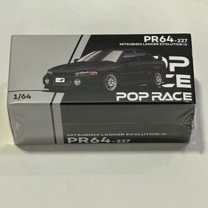 Puede incluir: Un modelo de coche Mitsubishi Lancer Evolution IV negro en una caja. La caja es gris y negra con el texto "PR64-227" y "POP RACE". El modelo es a escala 1/64.