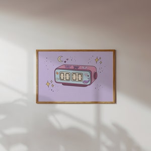 Puede incluir: Una impresión enmarcada de un reloj digital rosa con una esfera azul y una pegatina de ballena. El reloj está rodeado de estrellas y corazones sobre un fondo morado claro.