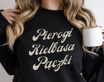 May include: Black sweatshirt with the words "Pierogi Kielbasa Paczki" in a retro font.