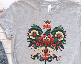 May include: A gray t-shirt with a colorful floral design of a Polish eagle. The eagle is a traditional symbol of Poland.