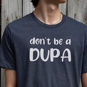 May include: A dark blue t-shirt with white text that reads "don't be a DUPA".