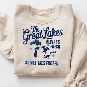 May include: A beige sweatshirt with a blue graphic of the Great Lakes, the text "The Great Lakes", "Always *Fresh", and "Sometimes Frozen".