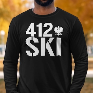 May include: Black long-sleeve shirt with the white text "412 SKI" and a Polish eagle emblem. The shirt is made of a soft material. The design is a bold, eye-catching statement.