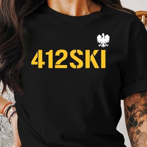 May include: Black t-shirt with a white eagle graphic and the text "412SKI" in yellow.