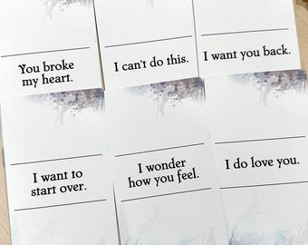 May include: Six rectangular white cards with watercolor-style purple and blue accents at the top and bottom. Each card features a horizontal line and black text: You broke my heart, I can't do this, I want you back, I want to start over, I wonder how you feel, and I do love you.