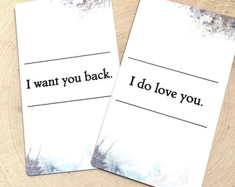 May include: Two rectangular white cards featuring watercolor-style gray and blue splatters at the corners. The left card displays the text I want you back. between two horizontal lines. The right card displays the text I do love you. between two lines.